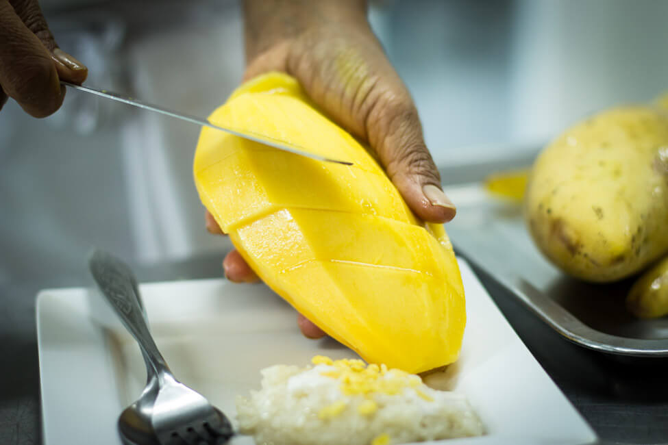 Thailänderin schneidet Thai Mango