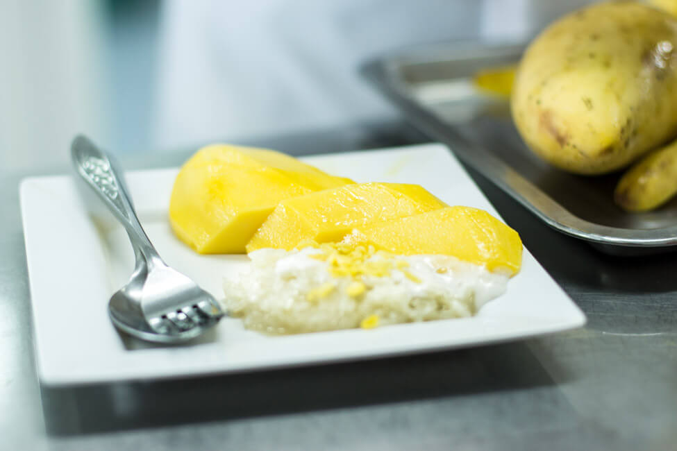Mango mit Sticky Rice auf weißem Teller in Bangkok