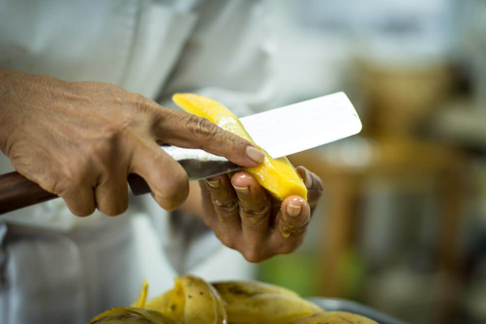 Thailänderin Chef Lenz schneidet gelbe Thai Mango