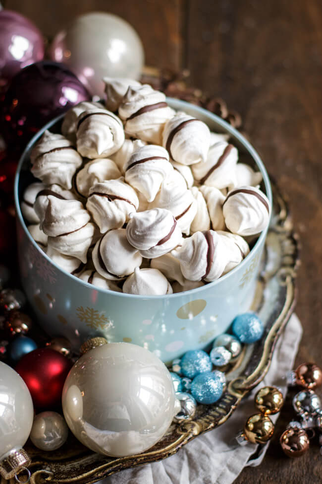 Feenküsschen - Baiser mit Schokolade in blauer Keksdose auf Weihnachtsteller mit Christbaumkugeln
