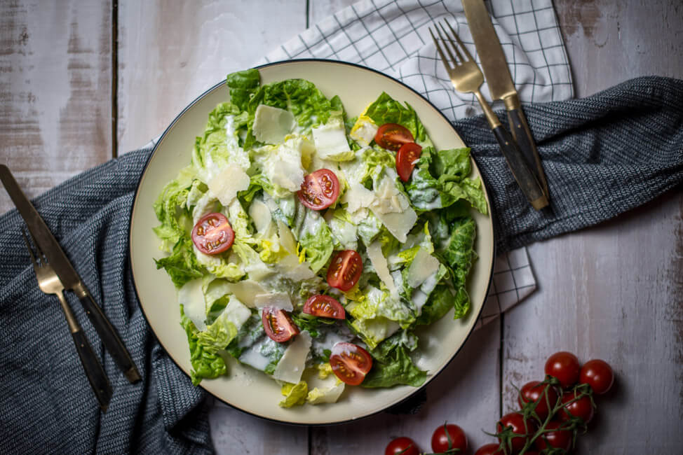 lowfat und lowcarb caesar salad auf weißem Porzellanteller und weißem Tisch