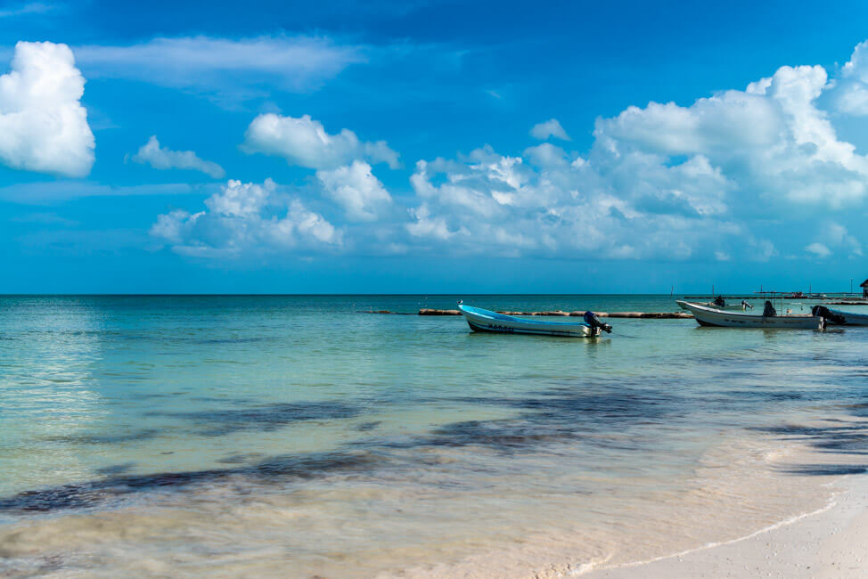 Isla Holbox Mexiko weißer Sandstrand Traumstrand Meer Boote türkisblaues Meer Karibik