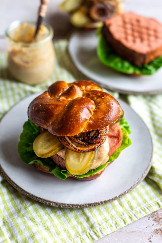Leberkäse Burger im Laugenbrötchen mit Essiggurken, gebratenen Zwiebeln und Meerrettich-Senf-Mayo