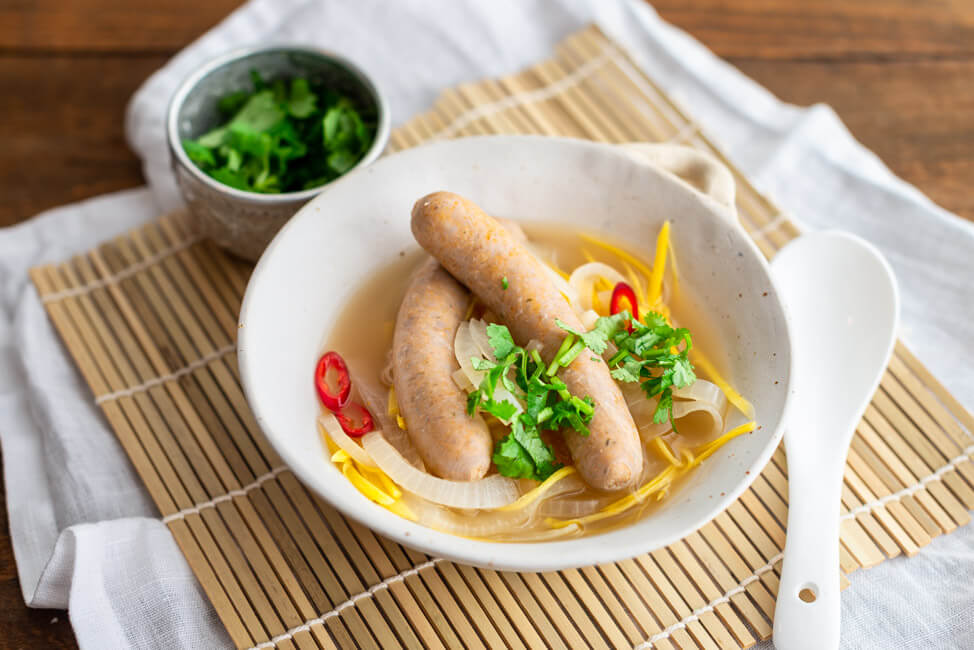 Saure Zipfel Thai Style mit reichlich Zwiebeln und Karotten im Essigsud mit Kaffirlimettenblättern und Zitronengras. Zu den Bratwürsten im Essigsud gibt es Koriander und rote Chili.