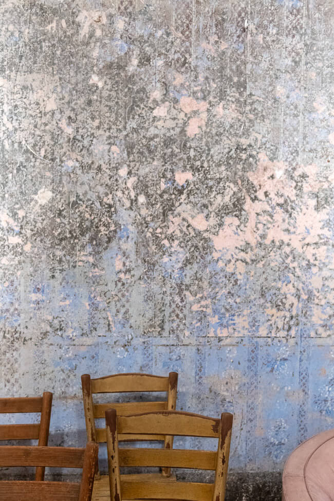 Schöne alte Wand mit Tapete und alte Holzstühle im Kaffeehaus im Aischgrund.