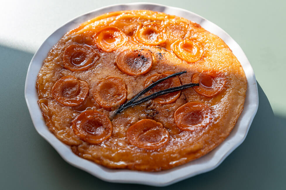 Tarte Tatin Pfannkuchen auf weißem Teller und grünem Tisch
