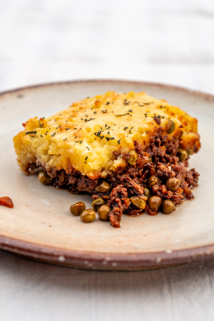 Ein Stück Sheperd's Pie auf hellem Keramikteller